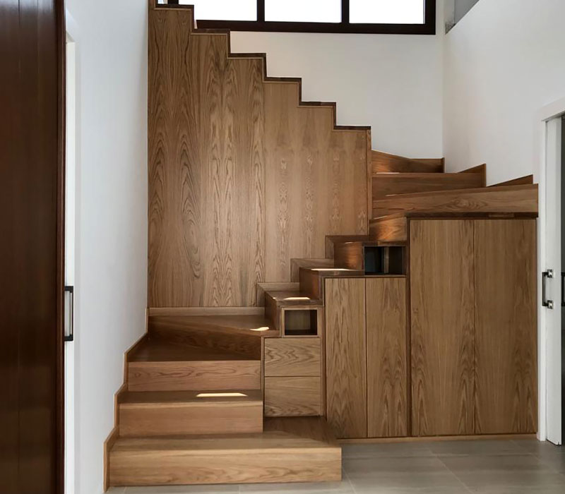 Escaleras de madera en vivienda que conduce a una segunda planta.